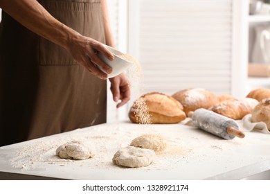 Young man preparing bread in kitchen