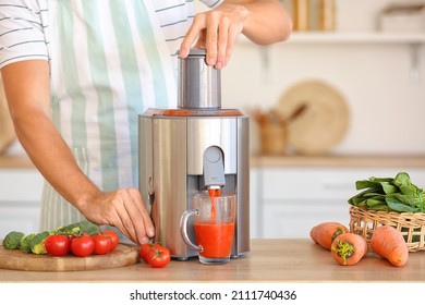 Young man preparing healthy vegetable juice in kitchen - Powered by Shutterstock