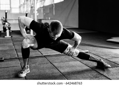 Young man preparing muscles before training. Muscular athlete exercising. Fit man stretching. Professional sportsman warming-up