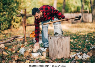 Young Man Preparing For The Winter On Countryside, Chopping Fire Wood.