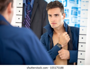 Young Man Preparing For Work, Dressing Up And Looking Himself In Mirror