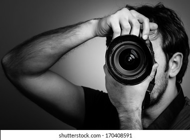 Young man with professional camera. Monochrome portrait - Powered by Shutterstock