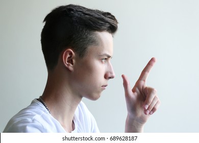 Young man in profile showing up finger