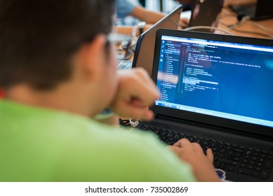 Young man programming on a laptop