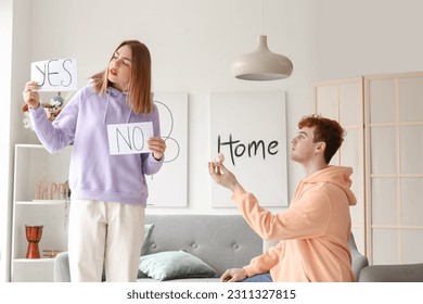Young man proposing to his hesitating girlfriend at home - Shutterstock ID 2311327815