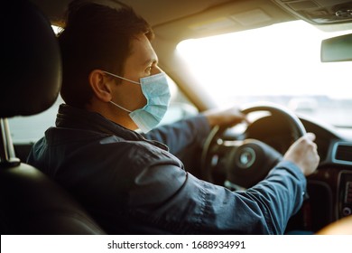 Young man in protective sterile medical mask driving car. The concept of preventing the spread of the epidemic and treating coronavirus, pandemic in quarantine city. Covid -19.