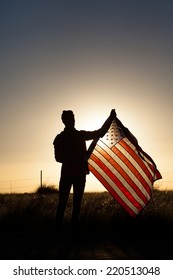 Young Man Proudly Waving The American Flag At Sunset