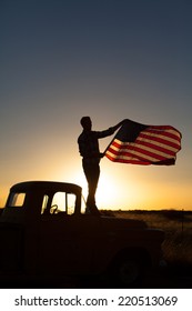 Young Man Proudly Waving The American Flag At Sunset