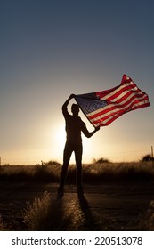 Young Man Proudly Waving The American Flag At Sunset