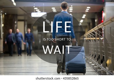 Young man pulling suitcase in modern airport terminal. Travelling guy walking away with his luggage while waiting for transport. Rear view with motivational text "Life is too short to wait"