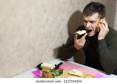 The Young Man Put A Piece Of Bread To His Ear Instead Of A Phone. Instead Of Bread, He Spread Butter On The Phone And Wants To Bite Off The Phone. Thoughts In My Head Do Not Allow Me To Focus On Food.