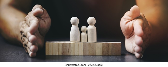 Young Man Puts His Hand Next To A Wooden Block, Care Concept, Protect, Keep Family Members Safe And Happy.