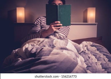 Young Man Is Reading In Bed