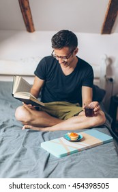 Young Man Reading Book In The Bed