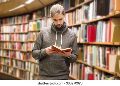 Young Man Reading A Book In Library