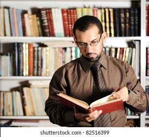 Young Man Reading Book In Library