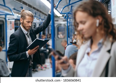 young man reading a book on a subway train. - Powered by Shutterstock