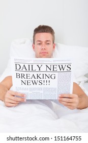 Young Man Reading Breaking News On Newspaper