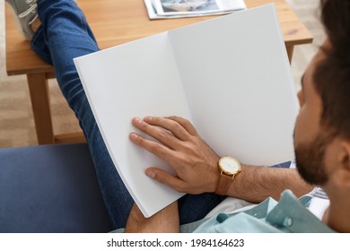 Young Man Reading Magazine At Home