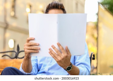 Young Man Reading Magazine Outdoors