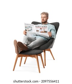 Young man reading newspaper while sitting in armchair on white background