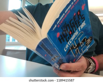 Young Man Reads Stephenie Morgan Meyer Hunger Games Series Book In Milan, Italy-September 2018