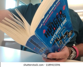 Young Man Reads Stephenie Morgan Meyer Hunger Games Series Book In Milan, Italy-September 2018