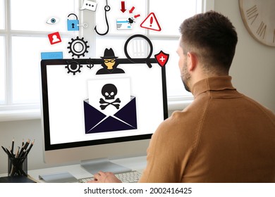 Young man with received infected email message on screen of computer at home