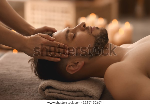 Young man receiving\
massage at spa salon