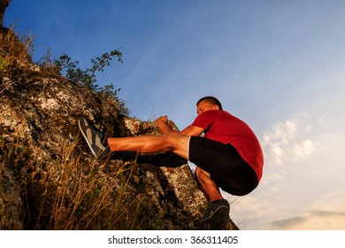 Young Man In Red Shirt Climbing On A Wall