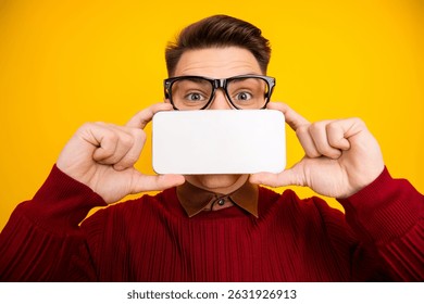 Young Man in Red Sweater Holding Blank Card on Vibrant Yellow Background