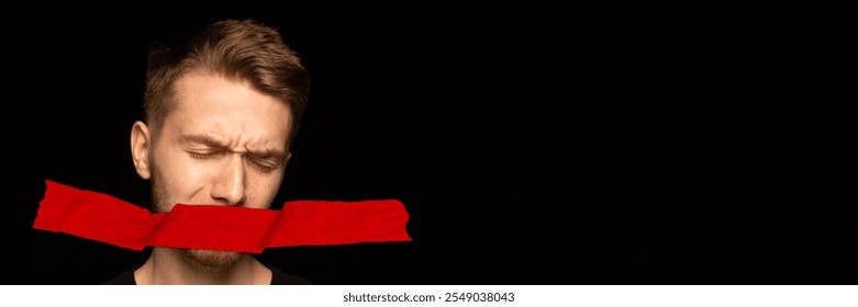 Young man with red tape covering his mouth, crying, symbolizing silenced voices and emotional oppression. Concept of human rights, social issues, freedom of speech, censorship. Banner. Copy space - Powered by Shutterstock