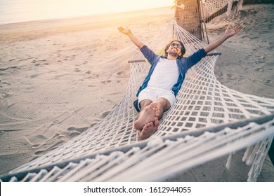 Young man relaxing in hammock on beach. Happiness, freedom of vacation and travel concept. Open arms. - Powered by Shutterstock