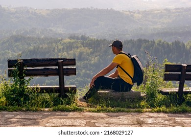 Young Man Relaxing And Looking Mountain View. Male Traveler With Backpack Enjoying Healing Climate And Nature Of Rhodope Mountains, Bulgaria. Vacation, Solo Travel, Welness, Eco Tourism Concept