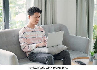 Young Man Relaxing On The Sofa With A Laptop