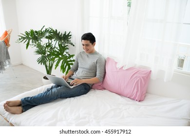 Young Man Relaxing On The Sofa With A Laptop