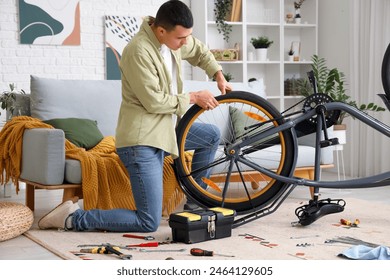 Young man repairing bicycle at home - Powered by Shutterstock