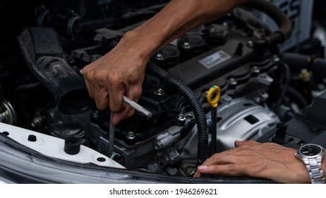 Young Man Repairing, Maintaining And Checking Cars In A Home Car Repair Garage. Car Service Business Concept.