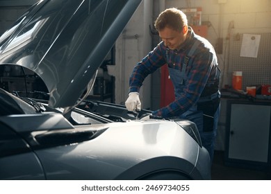 Young man repairing motor in vehicle service center - Powered by Shutterstock