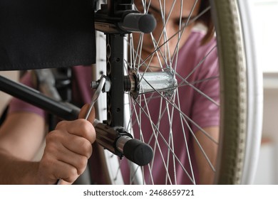 Young man repairing wheelchair at home, closeup - Powered by Shutterstock