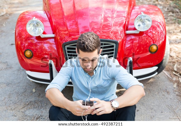Young man\
resting at car trip by the\
countryside