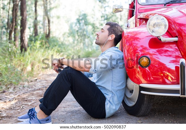 Young man\
resting at car trip by the\
countryside