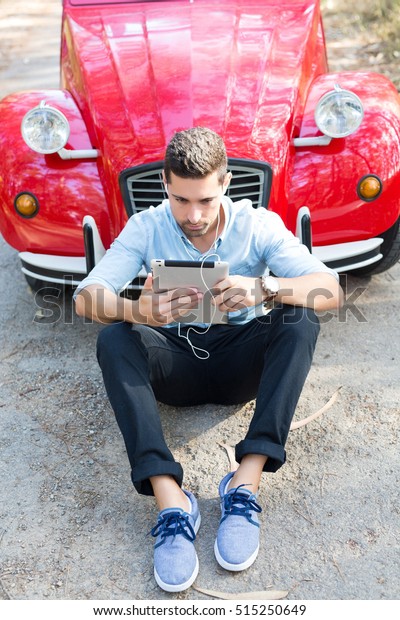 Young man
resting at car trip by the
countryside