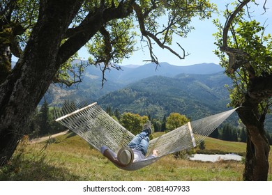 Young man resting in hammock outdoors on sunny day - Powered by Shutterstock