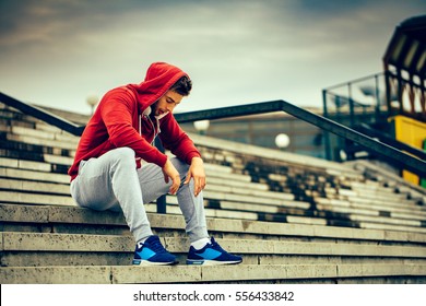 Young man resting on the stairs after running