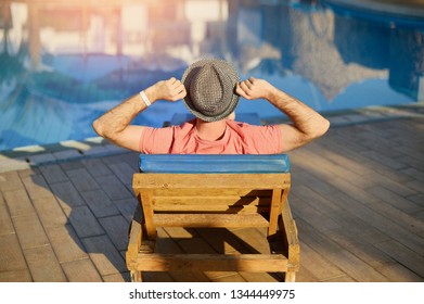 Young Man Resting On Sun Loungers By Swimming Relax in Pool summer on a sun lounger at the hotel on the background of sunset in Egypt, Sharm El Sheikh - Powered by Shutterstock