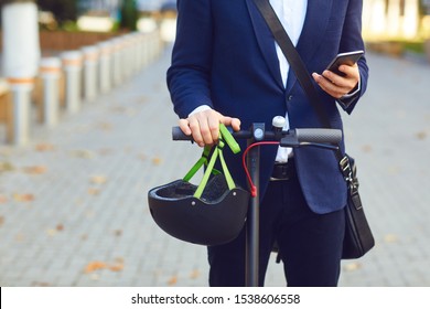 Young man in rides an electric scooter on a city street in summer
