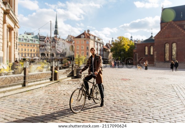 Young man riding a bike. Sustainable\
mobility transport New way of inclusive cities mobility. Green\
transportation. Sustainable climate neutral city goals. Green\
mobility and\
transportation