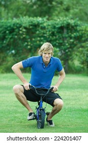 Young Man Riding Child's Bike, Full Length