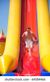 Young Man Riding Down A Water Slide